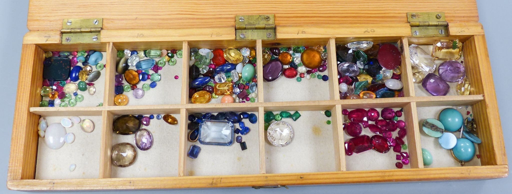 A quantity of unmounted gemstones, housed in a wooden box, including opal, opal doublet, bloodstone, turquoise, amethyst, rock crystal etc.